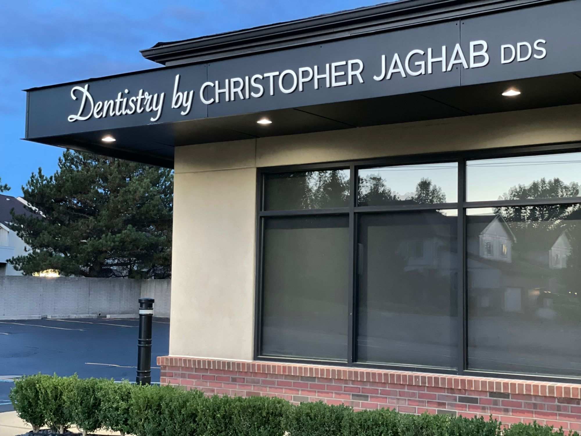 The Christopher Jaghab DDS office on Drake Road in West Bloomfield, its entrance canopy lit at dusk